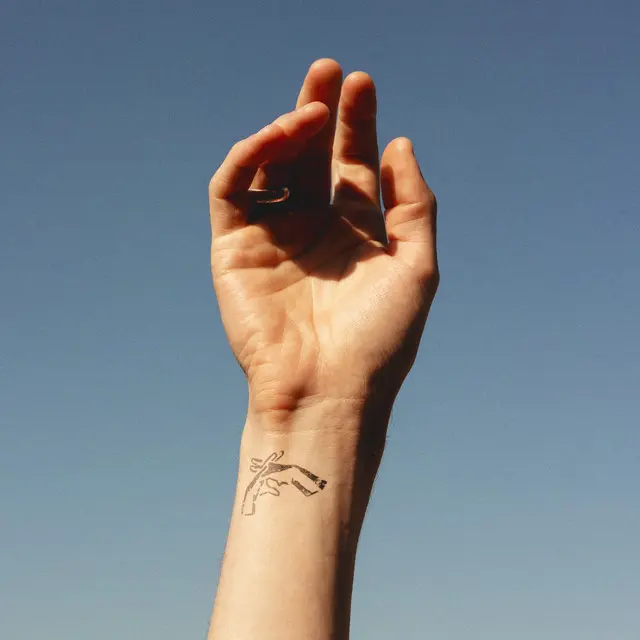 A person 's hand with a tattoo on it